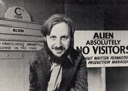 Dan O'Bannon on the set of Alien in 1978.[1] Note that on the sign behind him, "PERSON" has been replaced with "MONSTERS".