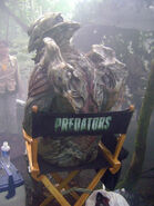 Behind the scenes image of Carey Jones as the River Ghost sitting in a Predators chair.[8]