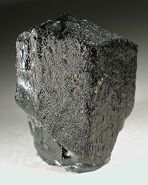 A raw, sharp, vitreous black Serendibite crystal from Mogok, Myanmar.