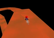 Mario goes down the slide.