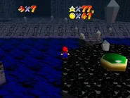 The entrance to Crawly Cave seen from the isle with the Metal Cap Switch; a ? Block containing a star is to the entrance's right.