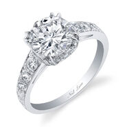 Chris & Katie A round brilliant-cut diamond, accented with 12 smaller diamonds set in a handmade platinum setting totaling 2 carats, by Neil Lane.