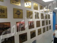 A placa com o logotipo do piloto fica na quarta fileira de baixo.