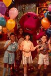 Barney and the children holding balloons.