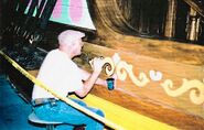 Painter E. "Bill" Slette lettering the side of the pirate ship.