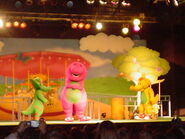 BJ appears on stage and greets Barney and Baby Bop.