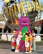 Barney in front of the Universal globe with kids