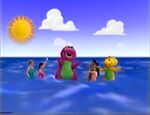 Barney, BJ, and the children have fun swimming in the ocean.