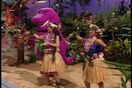 Kalea and Leilani do a hula dance as Barney plays the ukulele.