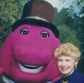 Barney the Dinosaur alongside Kathy Parker