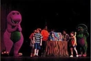 Barney and Baby Bop watch the kids look inside the Barney Bag.