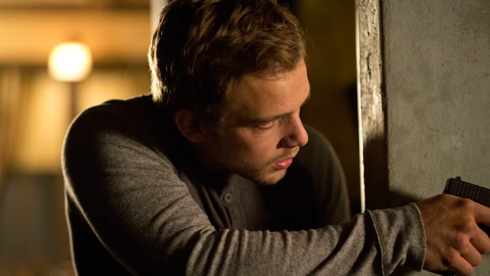 After a bullet grazes his arm, Dylan moves to the hallway, hoping to get a better shot at Shelby.