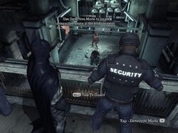 Batman and two Arkham security guards watch Zsasz's movements from a balcony as he holds Mike hostage in the room below.