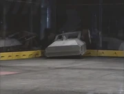 An impaled Kill-O-Amp gets slammed into the spikestrip, chucking out its top Lexan plate.