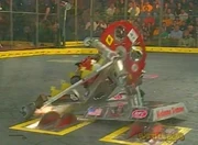 Alabama Slammer dragging Lollibot towards the killsaws.