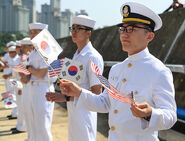 ROK Navy sailors in uniform, welcoming a visiting U.S. Navy warship.