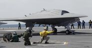 XB-74 is an experimental stealthy combat drone. She has limited strike capability, and is remotely piloted. This picture shows her aboard the USS George Washington during her first carrier-borne take off.