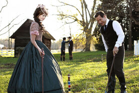 Elsa and Giuseppe playing Croquet; her brothers talking at the back