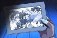 Ray holding a photo of the Bladebreakers in G Revolution