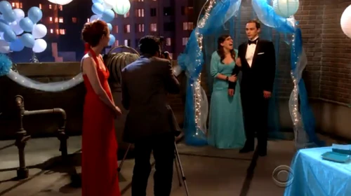 Raj taking a photo of Amy and Sheldon.