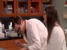 Amy observes Sheldon's work.