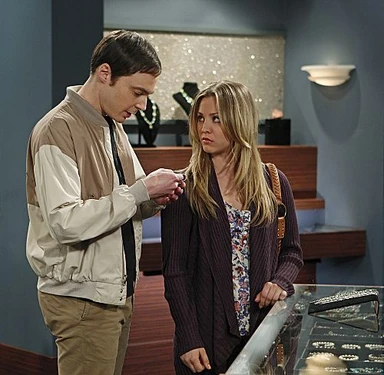 Sheldon and Penny look over an item at a jewelry store.
