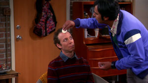 Raj applying makeup to Stuart's Face