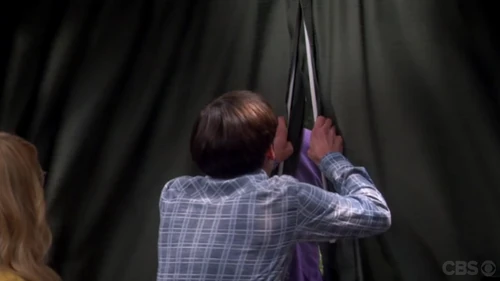 Howard pulling the drapes closed hiding Sheldon.