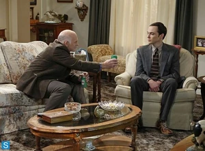 Mike offering Sheldon a beer after discussing football together.