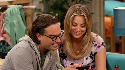 Leonard showing Penny photos from his trip.