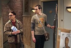 Sheldon holds his life-size Spock cutout as Leonard glances at Penny's apartment.