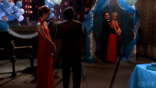 Taking Leonard and Penny's picture. Leonard is on his toes.