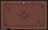 Four Attack Flies surrounding a plus of rocks in the center, with additional rocks and poop in the corners of the room.