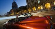 October 18, 2009: Vintage car with the Gran Teatro, El Capitolio in background, in Havana, Cuba