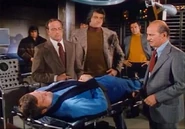 Rudy gives Steve a shot in his bionic leg.