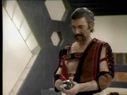 The second alien considers using a Liberator hand gun