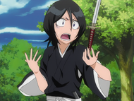 Rukia struggles to grab her Zanpakutō after Kaien tosses it to her.