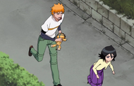 Ichigo runs behind Rukia while holding Kon.