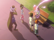 Raku passes over as Don Kanonji and the others watch.