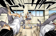 Tatsuki protects Orihime from the possessed students.