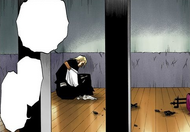 Izuru sits in his damaged cell.