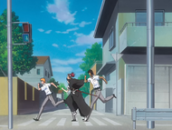 Sado and his friends run frantically down the street.