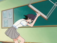 Tatsuki attacks Kon with a desk.