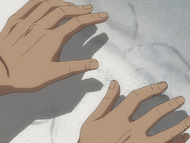 Sado's hands repel the sand when he holds them close to it.