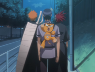 Kon is outraged to find himself strapped to Uryū's back.