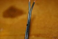 An AC Adapter with a white stripe on it connects to the positive side of the battery. The plain black wire connects to ground.