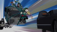 Izuku uses Blackwhip to haul citizens in a bus away.