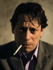 Dominic Greene mit Quantum-Anstecknadel - Publicityfoto von Mathieu Amalric.