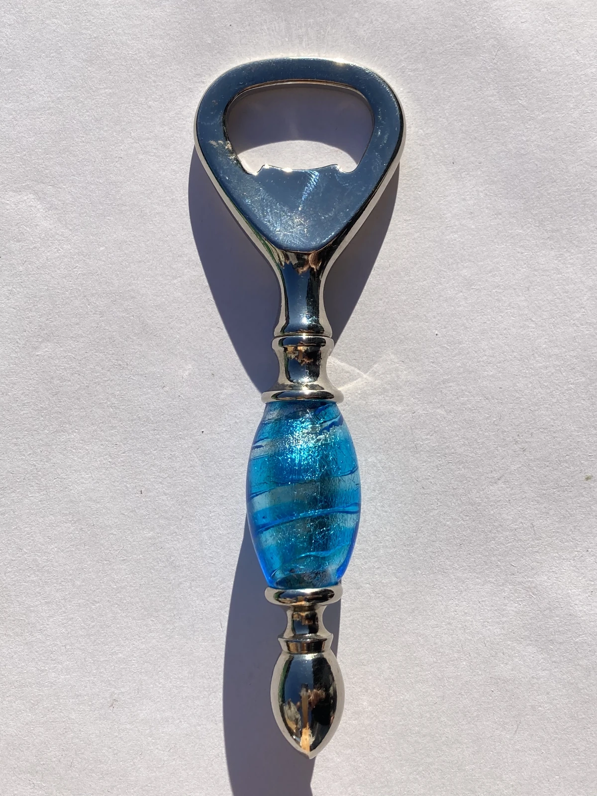 Shiny metal bottle opener with light blue Murano glass handle Bottle