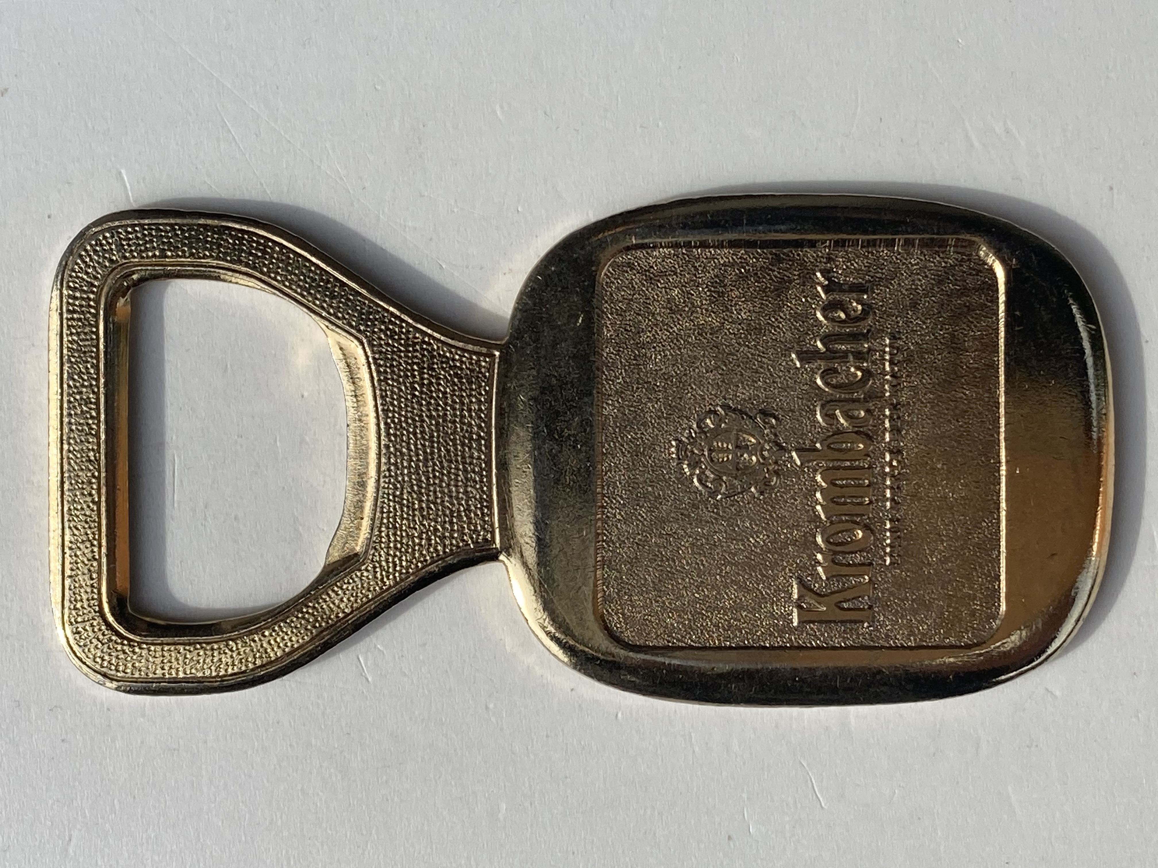 Krombacher golden metal bottle opener with rectangle-shaped body